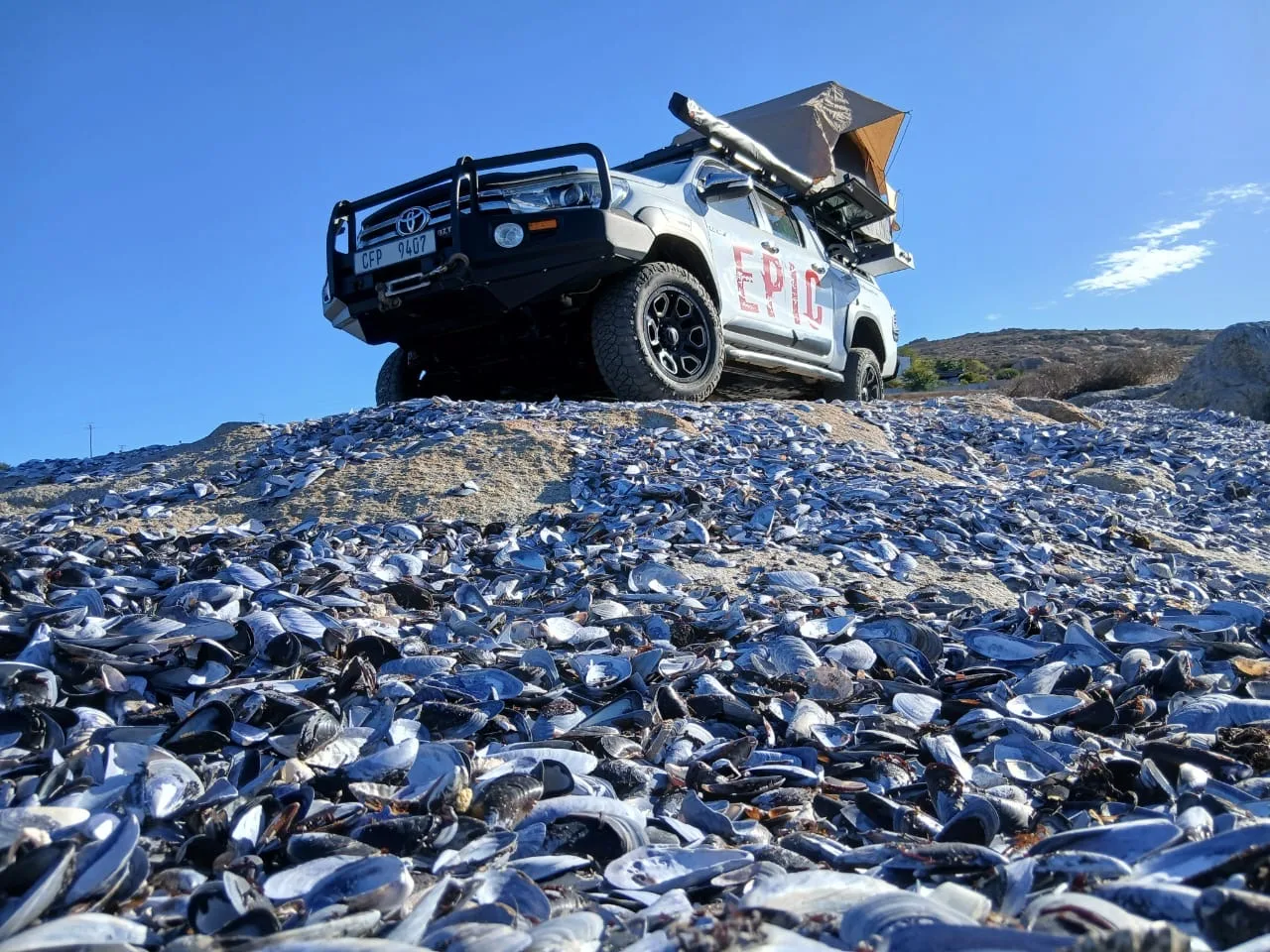 A fully expedition-rigged Toyota Hilux, three-quarter view